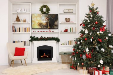 Odada şöminenin yanında güzel dekore edilmiş Noel ağacı. Şenlikli iç tasarım