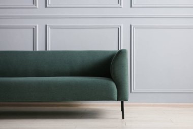 Gri duvarın yanında şık bir kanepe.