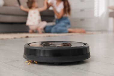 Anne, kızıyla aynı odada vakit geçiriyor. Robotik elektrik süpürgesine odaklanıyor.