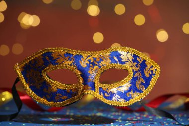 Renkli arka planda güzel bir karnaval maskesi ve konfeti, yakın plan