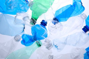 Kırışmış plastik şişeler beyaz arka planda, yakın plan.