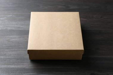 Ahşap arka planda boş bir karton kutu. Tasarım için model