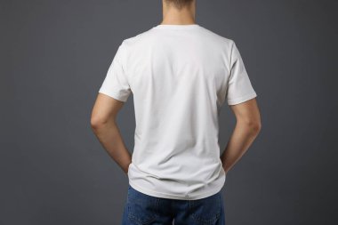 Gri arka planda, şık tişörtlü bir adam. Tasarım için model