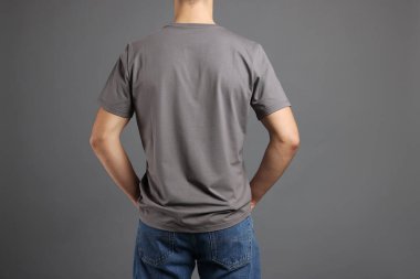 Gri arka planda, şık tişörtlü bir adam. Tasarım için model