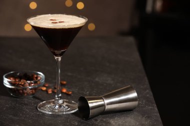 Lezzetli espresso martini, kahve çekirdekleri ve bardaki jigger. Metin için boşluk