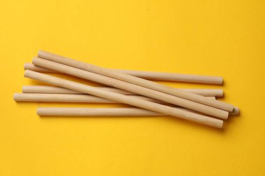 Sarı arka planda bambu pipetleri, üst görünümde