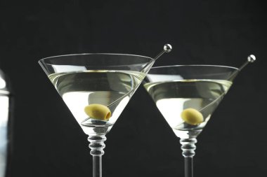 Siyah arka planda zeytinli martini kokteyli, yakın plan.