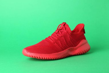 Yeşil arka planda şık kırmızı bir spor ayakkabı. Spor ayakkabıları.