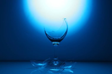 Kırık şarap kadehleri koyu mavi renge karşı.