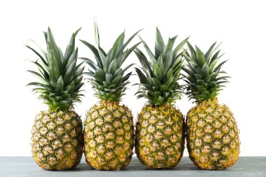 Taze olgun ananaslar gri masada beyaz arka planda