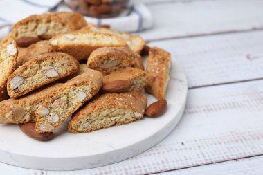 Lezzetli bademli bisküviler (Cantuccini) ve hafif ahşap masada fındıklar, yakın plan. Metin için boşluk