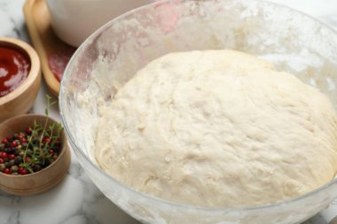 Calzone pizzası yapıyorum. Beyaz mermer masadaki farklı malzemeler, yakın plan.