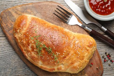 Tahta masada servis edilen leziz taze calzone pizzası.