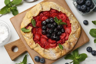 Böğürtlenli ve nane şekerli güzel bir galet beyaz mermer masa, düz uzanmış