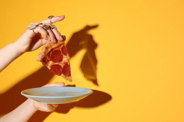 Turuncu arka planda lezzetli pizzası olan kadın, yakın plan. Metin için boşluk