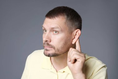 Gri arka planda yumruk yumruğa hareket eden bir adam.