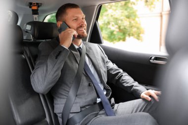 Modern arabada telefonla konuşan mutlu bir adam.