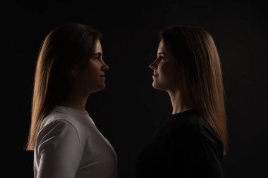 Siyah arka planda güzel ikiz kız kardeşlerin portresi