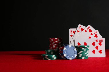 Poker çipleri ve oyun kartları kırmızı masada, metin için boşluk
