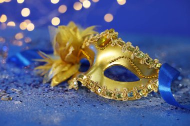 Mavi parıltılı arka planda güzel bir karnaval maskesi bulanık ışıklara karşı, yakın plan. Bokeh etkisi