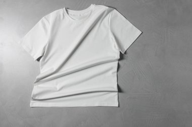 Gri desenli arka planda bir tişört, üst görünümde.