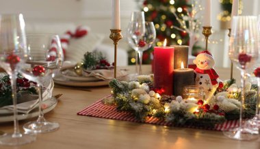 Christmas place setting with festive decor on wooden table in room clipart