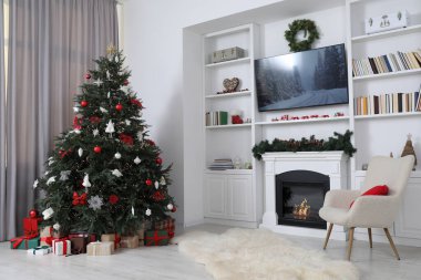 Odada şöminenin yanında güzel dekore edilmiş Noel ağacı. Şenlikli iç tasarım