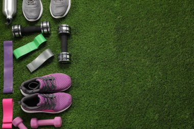 Yapay çimenlerin üzerinde farklı spor aletleri var. Metin için boşluk