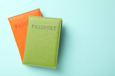 Açık mavi arkaplanda renkli pasaportlar, üst manzara. Metin için boşluk
