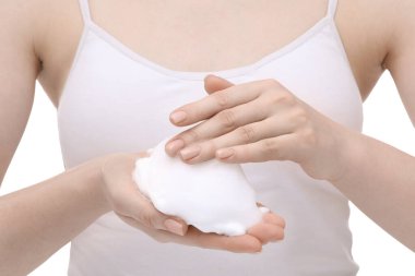Woman with cleansing foam on hands against white background, closeup