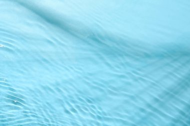 Açık mavi arkaplanda açık suyun dalgalı yüzeyi, üst görünüm