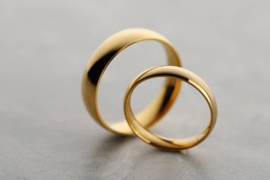 Gri arka planda güzel altın alyanslar, yakın plan.