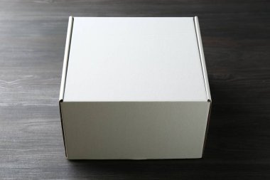 Ahşap arka planda boş bir karton kutu. Tasarım için model