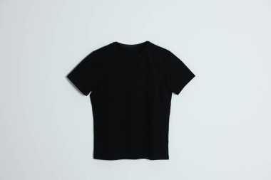 Açık arkaplanda bir siyah tişört, üst görünümde.