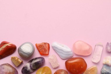 Açık pembe arka planda güzel doğal değerli taşlar, düz bir zemin. Metin için boşluk