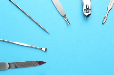 Açık mavi arkaplandaki pedikür aletleri, düz yatış. Metin için boşluk