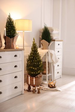 Noel ışıkları ve diğer dekorları olan küçük ladin ağaçları.