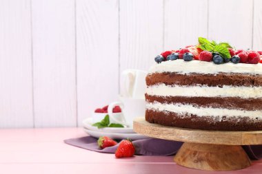 Pembe ahşap masada servis edilen meyveli lezzetli çikolatalı kek. Metin için boşluk