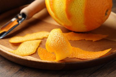 Taze portakal kabuğu ve meyve ahşap masada, yakın plan.