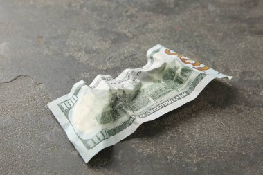 Gri masaya buruşmuş bir dolar banknot, yakın plan.