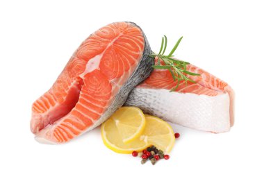 Taze çiğ somon biftekleri ve beyaz üzerine izole edilmiş baharatlar.