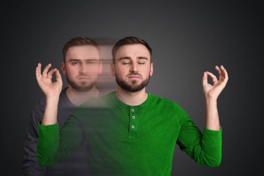 Gri arka plan, hareket bulanıklığı etkisi üzerine meditasyonun yardımıyla endişeden sakinliğe geçiş yapan genç adam. Psikolojik dayanıklılık