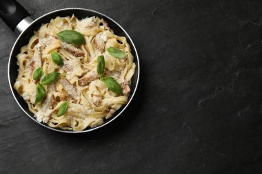 Siyah masada tavuklu, peynirli ve fesleğenli Alfredo makarnası. Metin için boşluk