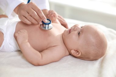 Pediyatrist, klinikte steteskoplu küçük bir çocuğu muayene ediyor. Bebeğin sağlığını kontrol ediyorum.