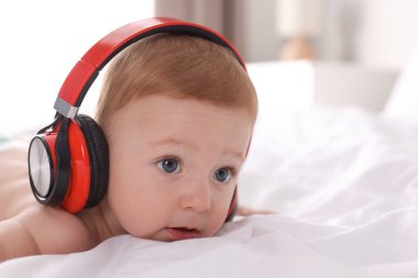Evde kulaklıklı şirin bir bebek, mesaj atmak için yer var.