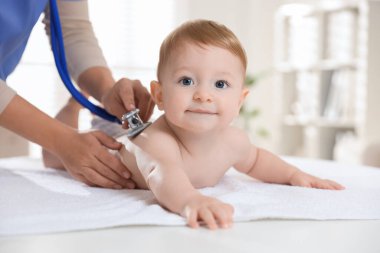 Pediyatrist, klinikte steteskoplu küçük bir çocuğu muayene ediyor. Bebeğin sağlığını kontrol ediyorum.