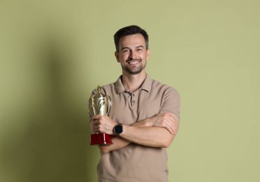 Altın kupalı, soluk zeytinli mutlu kazanan.