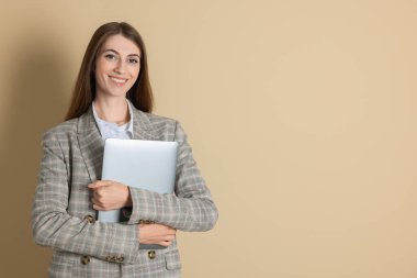 Bej arka planda dizüstü bilgisayarı olan gülümseyen bankacının portresi. Metin için boşluk