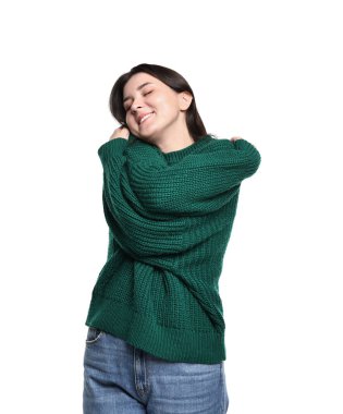 Beyaz arka planda kendine sarılan güzel bir genç kadın.