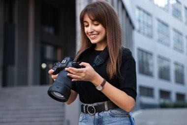 Binanın yakınında dijital kamerası olan profesyonel bir fotoğrafçı.